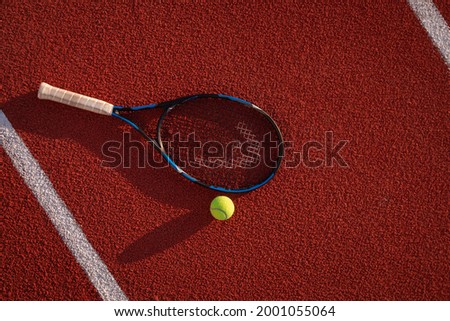 Tennis racket and ball on the court. Top view