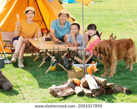 Happy family of four and dog camping out high quality photo