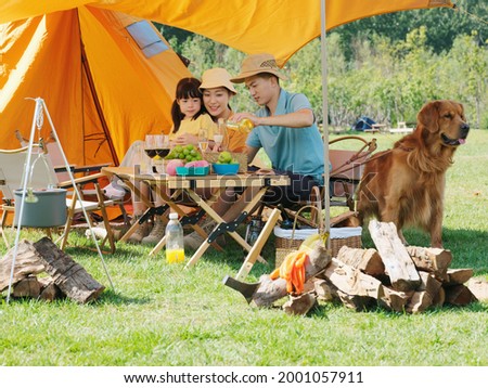 Happy family of three and pet dog have a picnic outdoors high quality photo