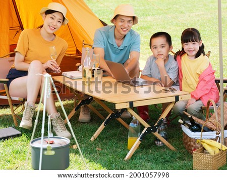 Happy family of four camping outdoors high quality photo