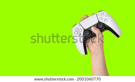 Kid holding game controller with green background for cropping