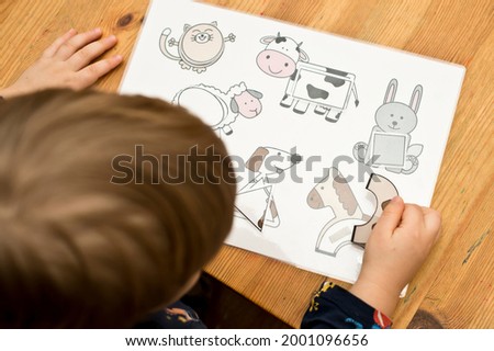 Animals and shapes. baby playing table game. preschool educational aid for kindergartens. children early learning montessori kit for intelligence and development. a glimpse of a concentrated toddler