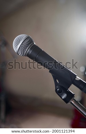 A gray microphone on a stand stands on the stage.