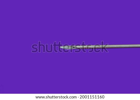 Macro photo of a syringe on a purple background.