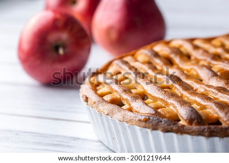 Homemade apple pie with red apples around