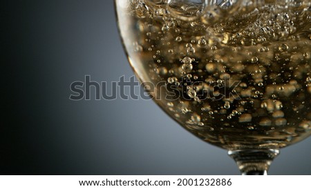 Detail of pouring white wine into glass, fresh beverages background
