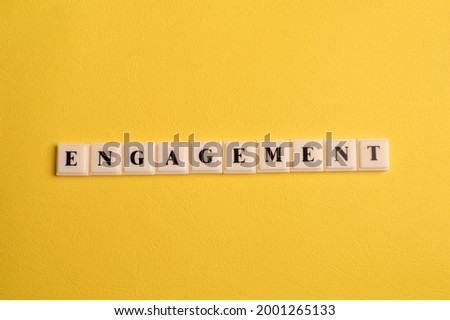 Square letters with text ENGAGEMENT isolated on yellow background
