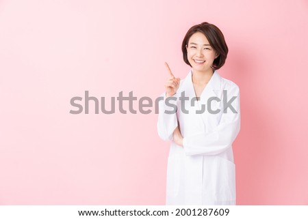 Young attractive asian woman in a white coat Royalty-Free Stock Photo #2001287609
