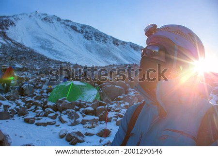 Hiker near the tents on the Pico de Orizaba covered with snow