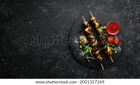Rapana skewers with vegetables on a black stone plate. Restaurant food. Seafood. Rustic style. Flat Lay. Royalty-Free Stock Photo #2001327269