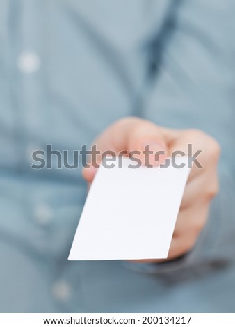 front view of blank business card in fingers close up