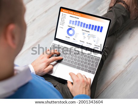 Man viewing website traffic analytics data on laptop computer Royalty-Free Stock Photo #2001343604