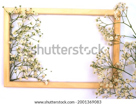 A romantic composition of flowers. White gypsophila flowers, photo frame on a white background. Valentine's Day, Easter, Birthday, Happy Women's Day, Mother's Day.Top view.