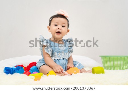 Baby girl smile and are happy when they play with their toys on  white background. Concept of child development.