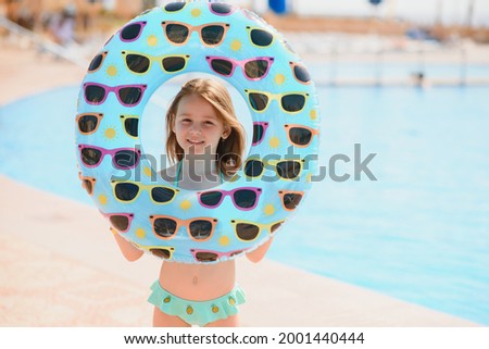 The concept of recreation at sea. The girl holds an inflatable circle for swimming by the pool