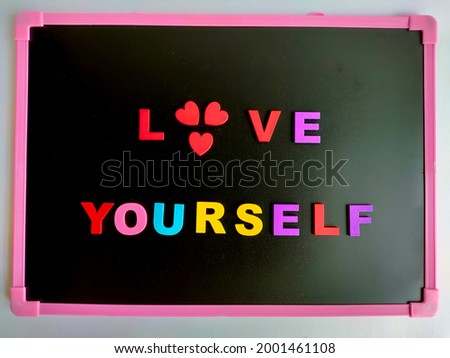 The wooden letters spelling Love Yourself concept on a small blackboard.