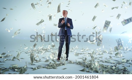 Cheerful businessman dancing under money rain