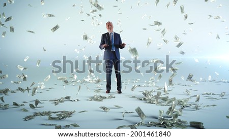 Cheerful businessman dancing under money rain