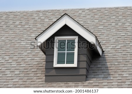 fake window on garret house and roof shingle with blue sky background. Asphalt Shingles or Bitumen Tiles.