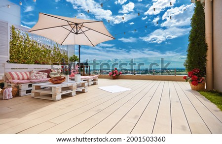 cozy rooftop patio with pallet furniture lounge zone and beautiful landscape view Royalty-Free Stock Photo #2001503360