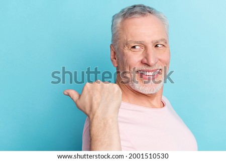 Photo portrait smiling elder man in pink t-shirt showing thumb copyspace recommending isolated pastel blue color background
