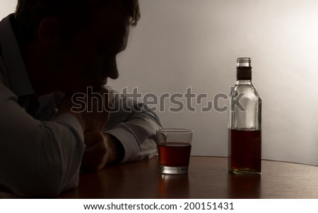 A young man alcohol abuse, on the table is alcohol Royalty-Free Stock Photo #200151431