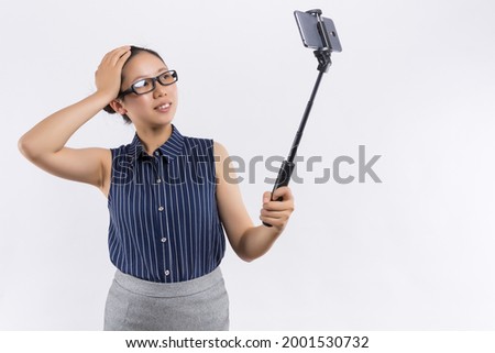 Back view of young woman taking pictures through cell phone, over white background