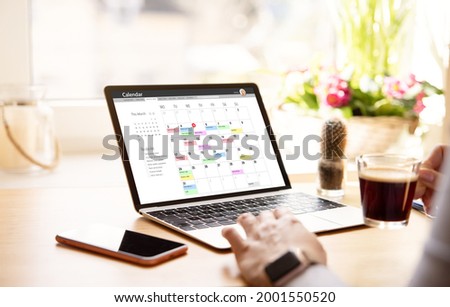 Woman looking at calendar on laptop computer Royalty-Free Stock Photo #2001550520