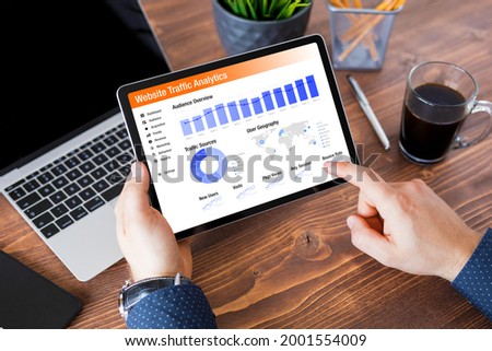 Man viewing website traffic analytics data on tablet computer Royalty-Free Stock Photo #2001554009