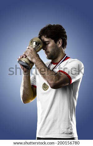 American soccer player, celebrating the championship with a trophy in his hand. On a blue background.