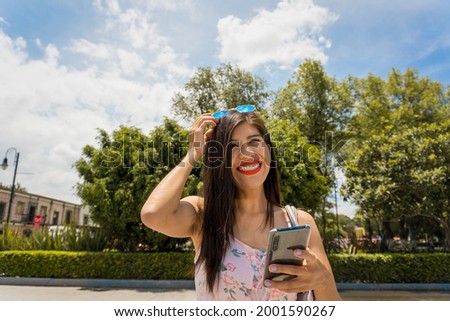 A cute happy female looking at her pictures via smartphone