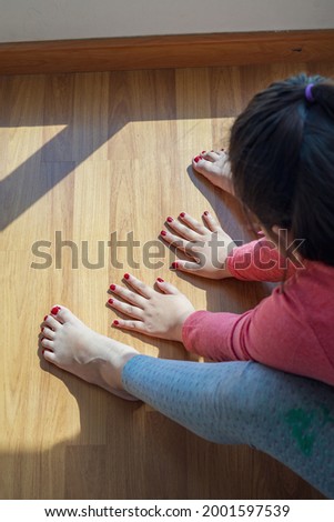 Hands and feet with henna in a bright sunlight on the floor. Drying henna at home.