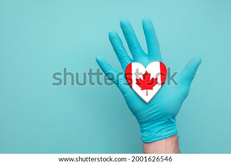 Canada medical health heart. Nurse hand holding country heart flag