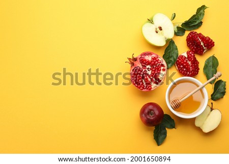 Flat lay composition with Rosh Hashanah holiday attributes on yellow background. Space for text Royalty-Free Stock Photo #2001650894