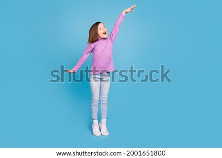 Full length body size little girl smiling showing heigh isolated pastel blue color background