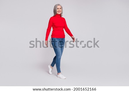 Full size profile side photo of attractive aged woman happy positive smile go walk step isolated over grey color background