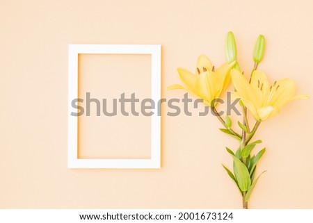 Mockup with a white frame and yellow lilies on color background