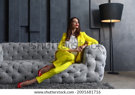 Beautiful businesswoman on sofa indoors. Luxury lifestyle Royalty-Free Stock Photo #2001681716