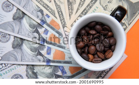 a cup full of coffee beans stands on dollar bills. Concept showing the rise or fall of coffee prices in the markets.