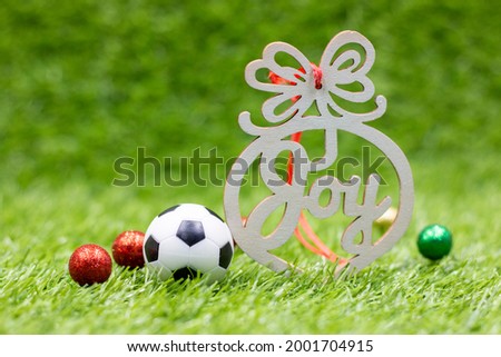 Soccer ball with word Joy for Christmas Holiday Decoration on green grass
