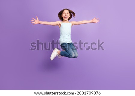 Full body photo of attractive crazy happy small girl jump up air enjoy free time isolated on purple color background