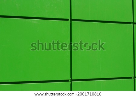 Facing panel on the house. Green surface. Design in modern architecture. Bright color in the details of the building.
