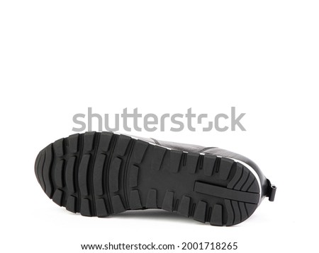 White and black leather sneakers. Casual women's style. White rubber soles. Isolated close-up on white background. Shoe sole view. Fashion shoes.