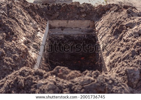 Freshly dug grave pit at cemetery, a close-up. Royalty-Free Stock Photo #2001736745