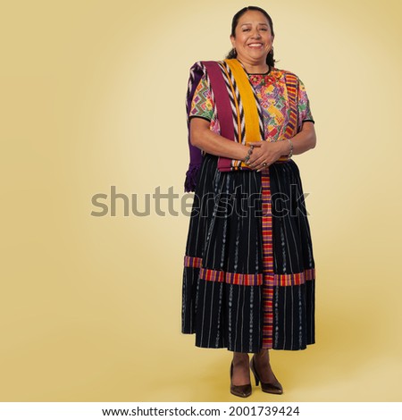 Portrait of an indigenous woman with a colorful costume from Quetzaltenango in the yellow background.