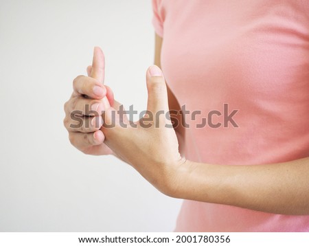Pain and numbness in the fingers woman massaging a sore finger on white background.