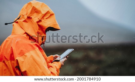 Woman using her mobile phone in the highlands Royalty-Free Stock Photo #2001784910