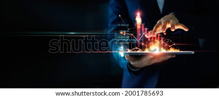 Business growth. Businessman holding tablet and a hot of fire glowing upright arrow with analyzing data and economic growth graph. Strategy. Stock market. Financial and banking. Digital marketing.  Royalty-Free Stock Photo #2001785693
