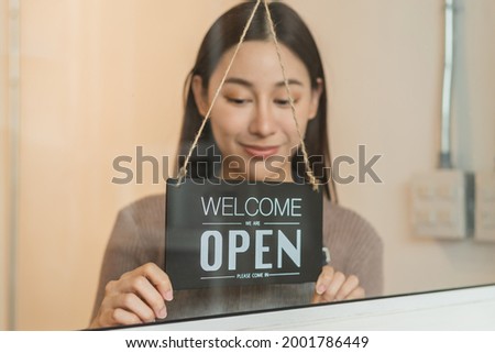 Smiling young asian business owner, employee retail,coffee shop woman,girl turning,setting sign board to open for welcome customer, reopen store after close lockdown quarantine in covid.Label concept.