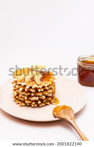 Belgian traditional waffles with honey and slice of various fruits. Sweet food, dessert background.